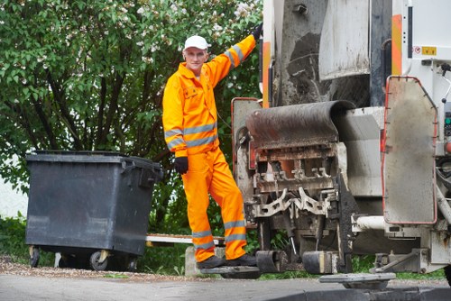 Operative loading a skip with protective gear